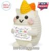 Crochet unicorn plushie with white yarn, yellow horn, pink cheeks, and a sign reading I may be a tiny unicorn.!