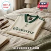 Off-white jersey with green v-neck, striped sleeves, Chavarria text, and Adidas trefoil logos on a beige bedspread.!