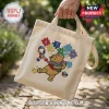 Beige canvas tote bag featuring an embroidered Winnie the Pooh character with autism awareness puzzle pieces and ribbon.!