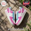 Custom Nike Air Force 1 sneakers in white, pink, and cyan with personalized text on a wooden surface.!