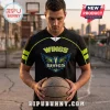 Man wearing a black Dallas Wings basketball jersey with lime green trim and a Pegasus wings logo on an outdoor court.!