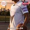 Man wearing a white Golden State Valkyries basketball jersey with purple trim and a black triangle graphic on a court.!
