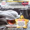 Yellow crochet star plush toy holding a message card next to a clear glass mug of tea and a gray knit blanket.!