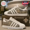 Adidas New Orleans Saints Who Dat Nation casual shoes featuring gold fleur-de-lis graphics and mascot art on white leather.