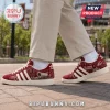 Adidas Oklahoma Sooners suede casual sneakers featuring crimson fabric, white stripes, and OU graphics on a campus background.
