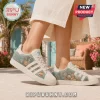Adidas x The Golden Girls Casual Sneakers featuring cream canvas, side graphics of the cast, and cheesecake illustrations.