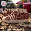 Alabama Crimson Tide Adidas Mascot Casual Sneakers featuring crimson red fabric, white stripes, and team logo on brick ground.
