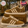 Alpha Phi Alpha Cornell University gold sneakers featuring Sphinx imagery, Greek letters, and white stripes on a shoe box.