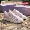 Ariana Grande x Adidas 7 Rings Lavender casual shoes featuring cloud graphics, white laces, and star accents on stone ground.
