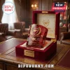Arsenal FC Premier League Champions embossed whiskey glass in a red velvet presentation box on a wooden desk.