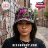 Blink-182 Neon Smiley Camo Cap with pink and green graffiti-style logo on a dark camouflage pattern fabric.