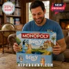Bluey Monopoly Collector Edition Board Game box held by a smiling man in a living room with a brown leather armchair.
