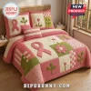 Breast Cancer Awareness Quilted 3-Piece Bedding Set with pink ribbons, floral patchwork, and green accents on a bed.