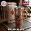 Brisbane Broncos 38th Anniversary Gold 40oz Stanley Tumbler featuring team logos, metallic finish, and decorative red gems.