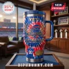 Buffalo Bills 1960-2026 Anniversary Edition Stanley Tumbler featuring red and blue tie-dye graphics and a stadium view.