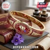 Delta Sigma Theta Elephant Hinge Bracelet featuring crimson enamel, gold-tone metal, and 1913 branding on a wooden desk.