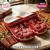 Delta Sigma Theta Red Crocs With Charms featuring custom Greek letter pins and 1913 accents on a patterned table runner.