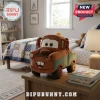 Disney Pixar Cars Tow Mater plush pillow featuring a brown and green truck design with a smiling face on a wooden table.