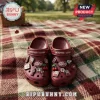 Dr Pepper Maroon Clogs with Charms featuring soda bottle, cherry, and brand logo embellishments on a picnic blanket background.