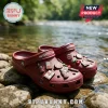 Dr Pepper Maroon Clogs with Charms featuring soda bottle and cherry decorations on a pebbled stream background.
