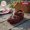 Dr Pepper Maroon Clogs with Charms featuring soda bottle and logo icons on a wooden surface with a picnic basket background.
