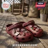 Dr Pepper Maroon Clogs with Charms featuring soda bottle, cherry, and brand logo accents on a wooden deck background.