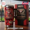 Essendon Bombers 154th Anniversary Stanley Tumbler with red and black flames, team crest, and jersey graphic on a desk.