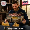 Fallout Monopoly Collector Edition Board Game held by a man wearing a blue Vault-Tec hoodie in a rustic wooden room.