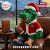 Florida Gators Santa Mascot Christmas Plush Toy wearing a red coat and hat, holding a football on a leather armchair.