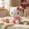 Hello Kitty Soft Plush Doll featuring white fur, a pink bow, and pink overalls sitting on a textured cream blanket.