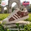 Indiana Hoosiers NCAA Mascot Casual Shoes in cream canvas with maroon team graphics on a stone surface outdoors.
