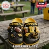 Iowa Hawkeyes NCAA Team Mascot Clogs With Charms featuring black and yellow rubber foam material on a wooden table.
