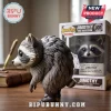 Jimothy The Raccoon Seattle Vinyl Figure standing in profile next to its branded display box on a wooden desk surface.