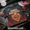 Jonas Brothers The Burning Up Tour concert shirt in black with a fiery graphic logo and text on a dark wooden surface.