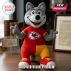 Kansas City Chiefs Wolf Mascot Plush Toy wearing a red team shirt and red and yellow pants on a wooden desk.