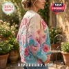 Karol G Mañana Sera Bonito ugly sweater featuring pastel floral, butterfly, and heart embroidery on a beige knit fabric.
