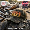KISS Band Golden Logo Camo Baseball Cap sitting on a black leather jacket with a motorcycle in the background.