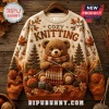 Knit Your Happy Season Autumn Cable Knit Sweater featuring a teddy bear knitting with yarn, pine trees, and maple leaves.