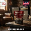 Metallica 45th Anniversary Edition Whiskey Glass in deep red with gold emblem details sitting on a weathered wooden table.