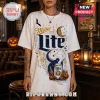Miller Lite Halloween Skeleton T-Shirt 2026 featuring a beer can graphic, crescent moon, bats, and pumpkins on white fabric.