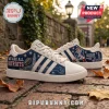 New England Patriots Adidas casual sneakers featuring blue team graphics, lighthouse imagery, and text on a brick pathway.