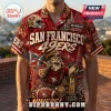 NFL San Francisco 49ers Mascot Hawaiian shirt featuring gold miner graphic, team helmets, football, and red palm leaf print.