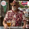 Oklahoma Sooners NCAA Maroon Hawaiian Shirt featuring team logos, tropical patterns, and Norman, OK text on a man.