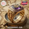 Omega Psi Phi Fraternity Premium Amethyst Ring in gold with a central purple stone sitting on an antique brass compass.