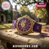 Omega Psi Phi Gold Tone Purple Watch featuring a purple face, Greek letters, and a matching canvas band on a stone ledge.