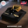 Ozzy Osbourne Custom Name Embroidered Black Polo Shirt featuring a gold bat logo and yellow ribbed collar on a wood table.