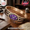 Ozzy Osbourne Prince of Darkness hinged bracelet in gold and black with a purple gemstone, bat emblem, and cross details.