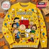 Peanuts Snoopy Yellow Crewneck Ugly Sweater featuring Charlie Brown, Lucy, and Linus characters on a wooden background.