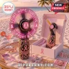 Pink Ribbon LED Rechargeable Hand Fan with floral patterns, cancer awareness ribbons, and text on a tropical beach table.