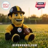 Pittsburgh Steelers NFL Mascot Plush Doll wearing a black and yellow construction hat and overalls on a grass field.